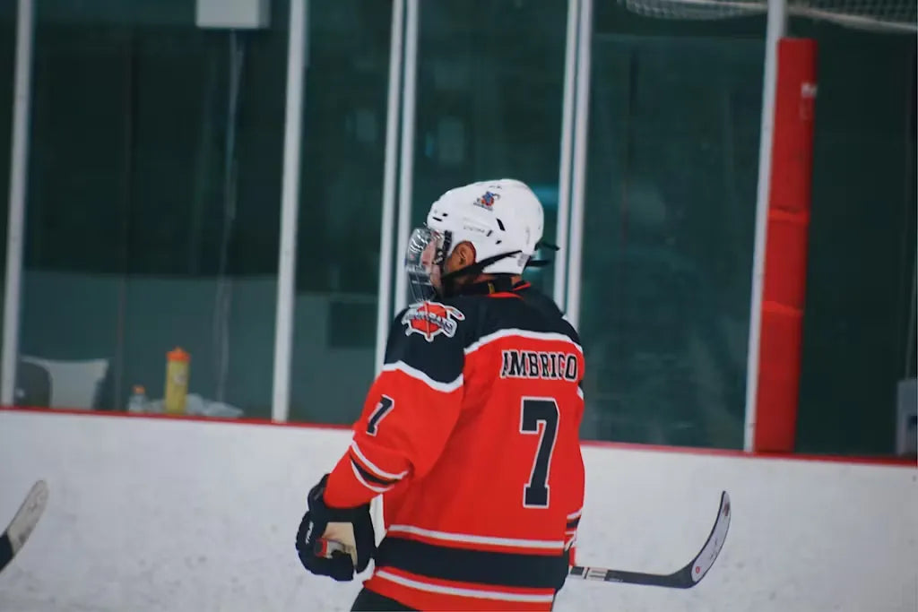Rink Rats player wearing number 7 on the back of an orange and black custom jersey