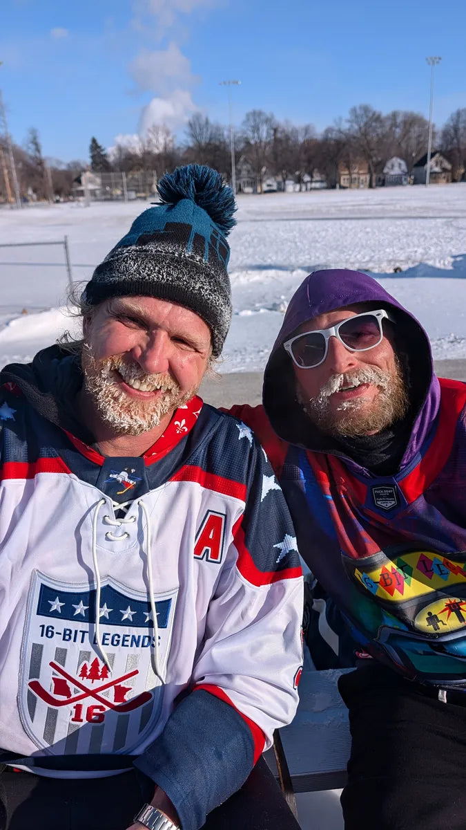 Two 16-Bit Legends players with frosty beards smiling in their custom jerseys outdoors